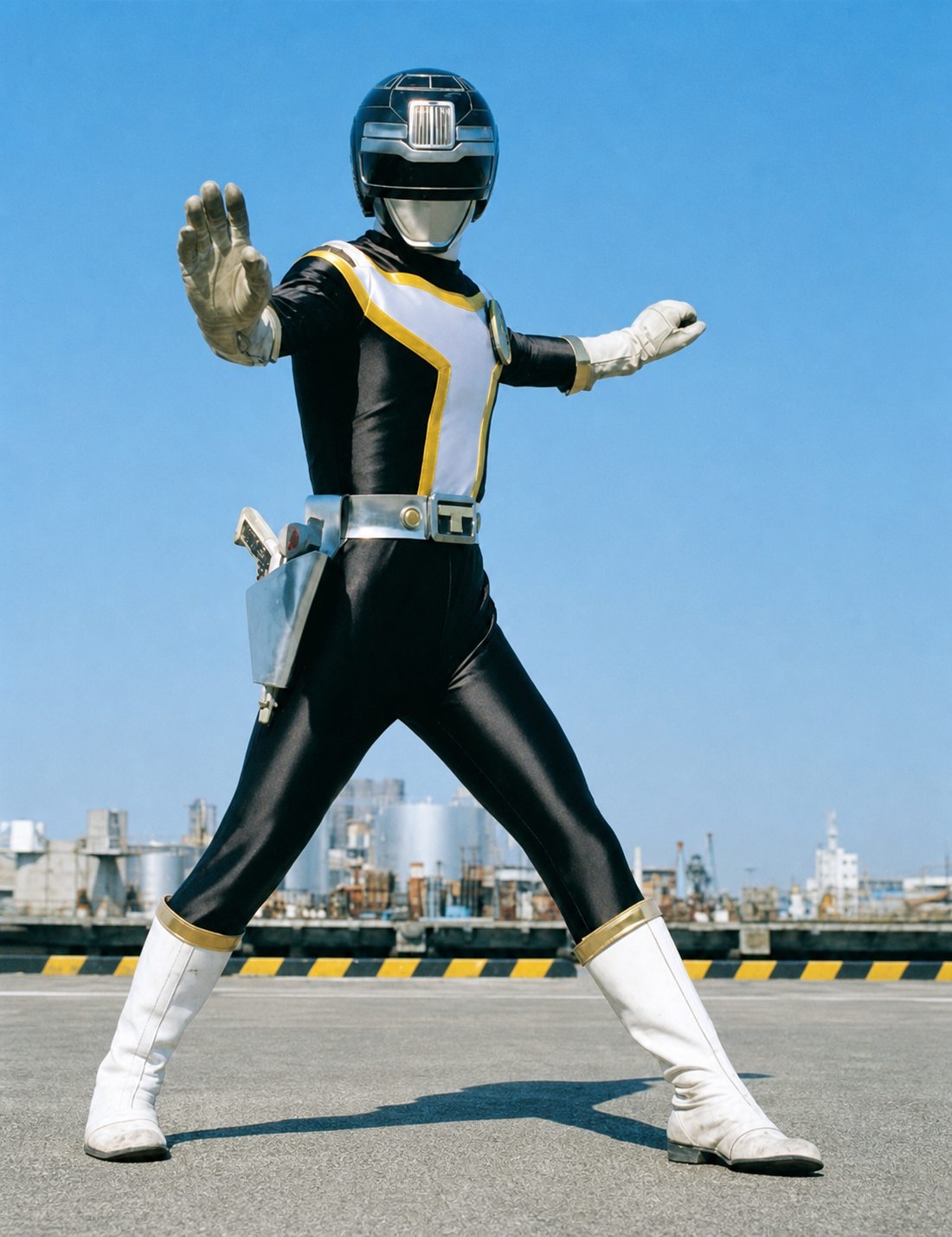Herói de tokusatsu em pose de combate num cais